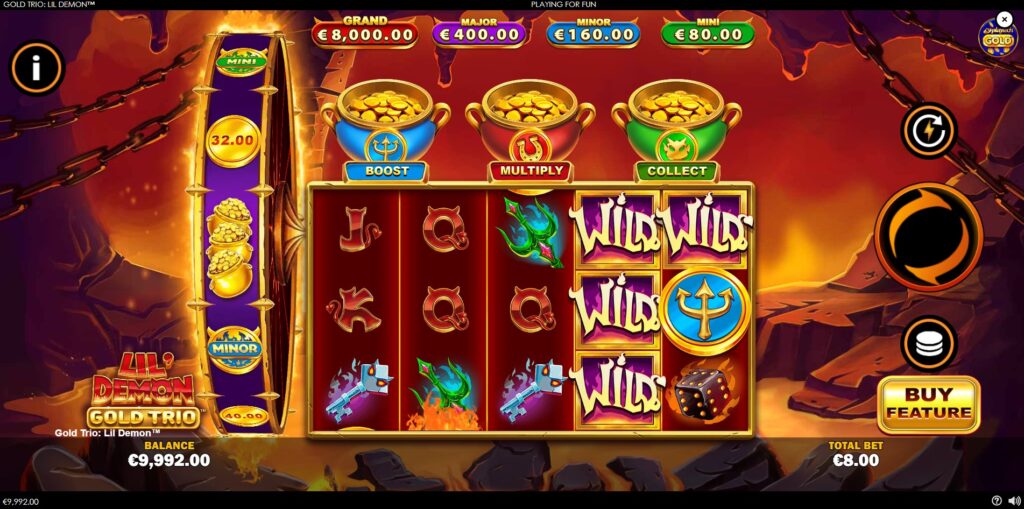 Main game screen of Gold Trio: Lil' Demon slot by Playtech, featuring the character, 5x3 reels, gold trio pots, and jackpot display.